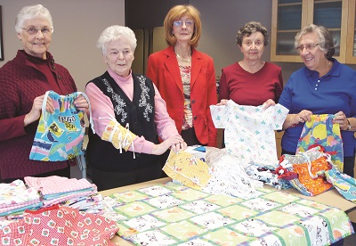 Under the guidance of Joan Levert (second from left), Joan Wilkinson, Grace Rock, Barbara Palmer, and Margaret Shaw (absent) created 206 items total for the life-saving project, Operation Smile, posed here with representative Maureen Atcheson (centre). This program aids children around the world who have cleft palet issues that can lead to starvation, rejection and stoning by their peers. It currently runs in 60 countries and involves thousands of volunteers, including over 5,000 medical personnel. Auroran photo by Sylvia Dickens