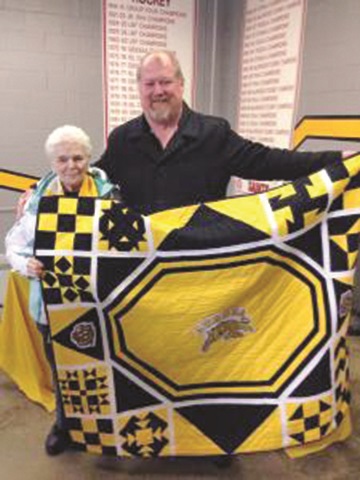 Tigers fans Joan Levert poses with the quilt she created for the Aurora Tigers, and the winner of the raffle, Brian Walter. Submitted photo