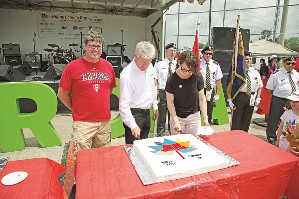 Following the Parade, festivities shifted to Lambert Willson Park for a full day of fun and an evening of music and fireworks. Here, MP Kyle Peterson, Aurora Mayor Geoff Dawe, and Ulrika Liljeberg, Mayor of Leksand, Sweden, Aurora's Twin Town, cut the Sesquicentennial cake.